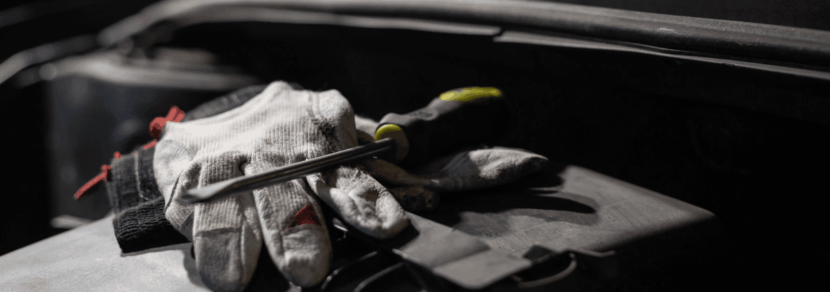 mechanic gloves with a flat head screw driver on top - ADL Auto Repair & Driveshafts