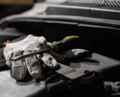 mechanic gloves with a flat head screw driver on top - ADL Auto Repair & Driveshafts