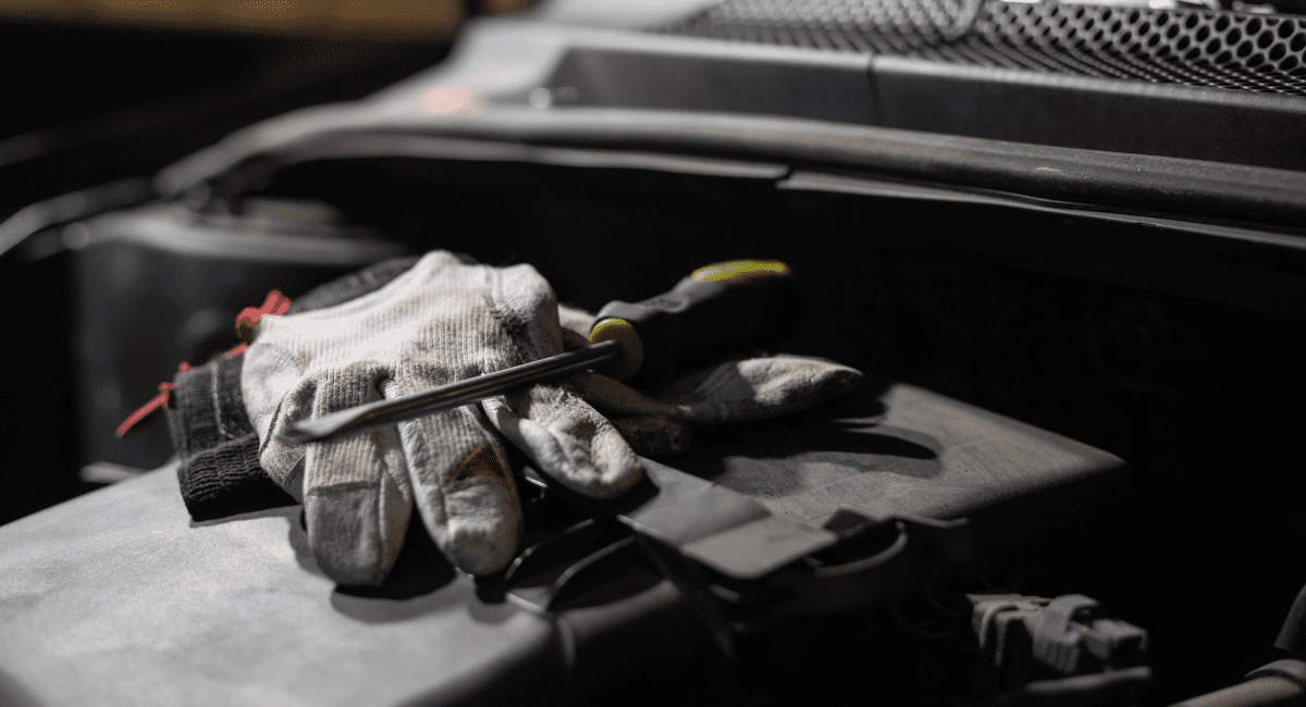 mechanic gloves with a flat head screw driver on top - ADL Auto Repair & Driveshafts