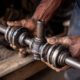 mechanic holding a worn out driveshaft - ADL Auto Repair & Driveshafts Driveshaft Balancing and Maintenance