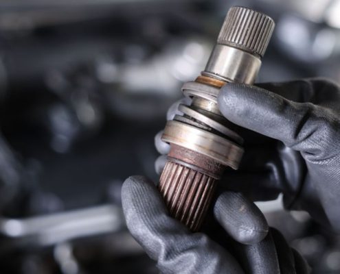 mechanic with a vehicle driveshaft - ADL Auto Repair & Driveshafts suspension repair