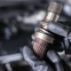 mechanic with a vehicle driveshaft - ADL Auto Repair & Driveshafts suspension repair