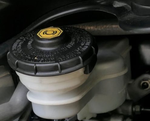 engine bay of vehicle with a close up of transmission fluid topper - ADL Auto Repair & Driveshafts vehicle maintenance