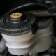 engine bay of vehicle with a close up of transmission fluid topper - ADL Auto Repair & Driveshafts vehicle maintenance