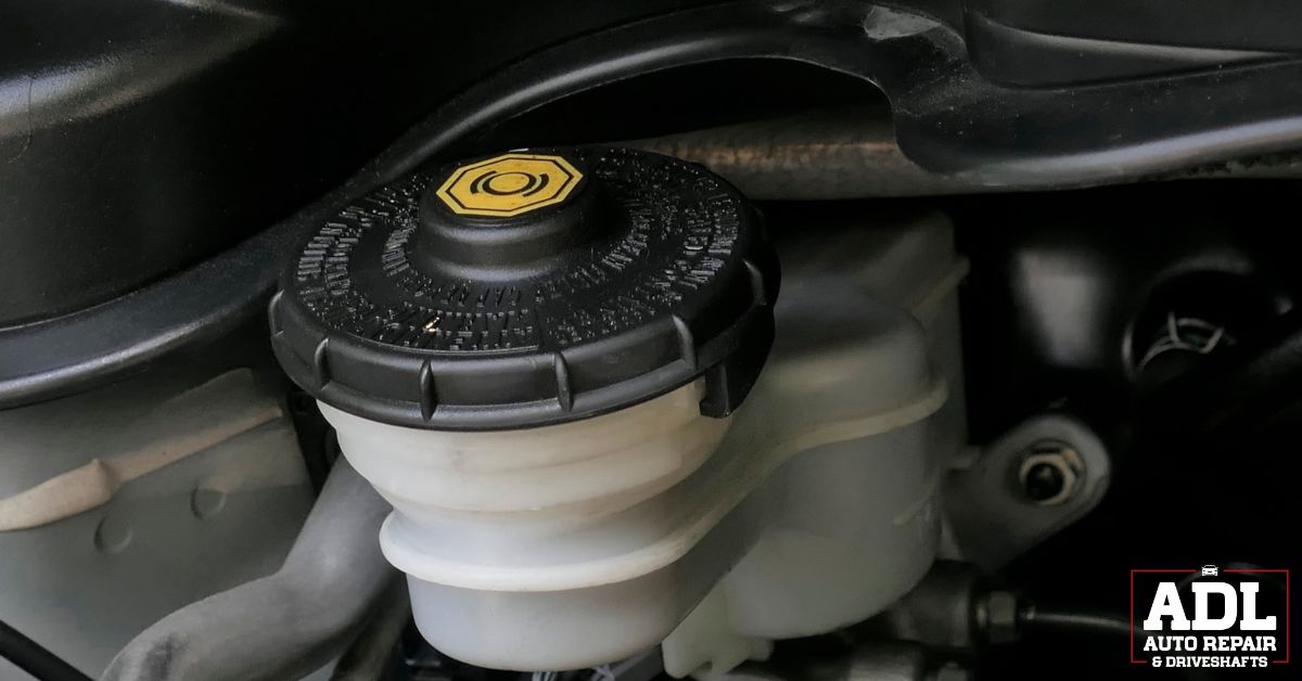 engine bay of vehicle with a close up of transmission fluid topper - ADL Auto Repair & Driveshafts transmission fluid