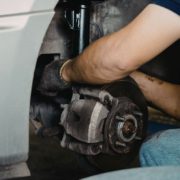 ADLAutoRepairandDriveshafts-brake-service-021020261 mechanic inspecting vehicle brake system - ADL Auto Repair & Driveshafts brake service