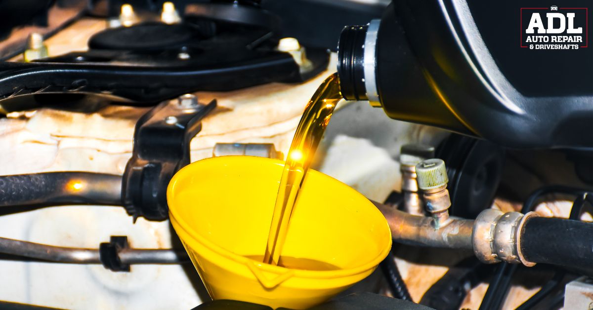 new oil being poured into a yellow funnel - ADL Auto Repair & Driveshafts oil change
