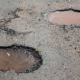road with pot holes filled with water - ADL Auto Repair Driveshafts suspension repair